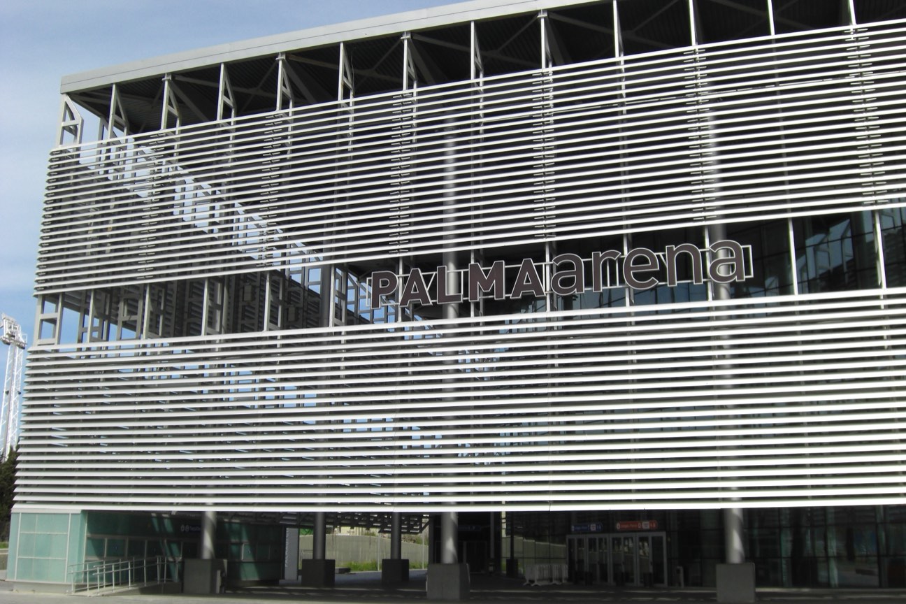 Fachada del Palma Arena cubierta de lamas metálicas horizontales, con el nombre del recinto en letras grandes y las puertas de acceso en la planta baja
