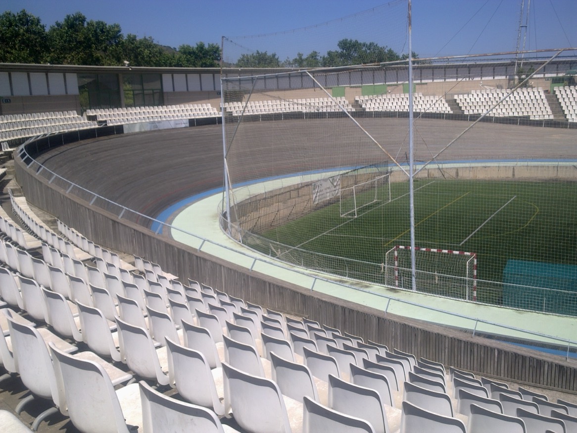 Pista descubierta del Velòdrom d'Horta con gradas de asientos blancos y un campo de fútbol de hierba artificial en el interior
